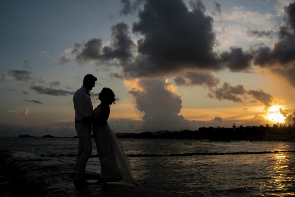 Couple holding each other on the beach during sunset