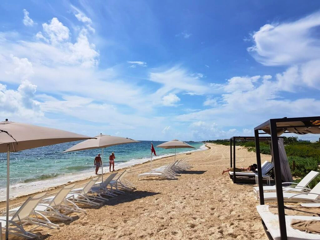 Resort beach area with a few sunn beds and umbrellas
