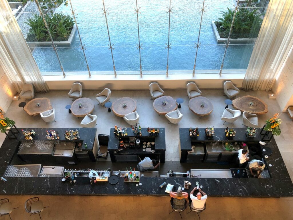 Resort lobby bar from avobe with a big glass wall and a pond