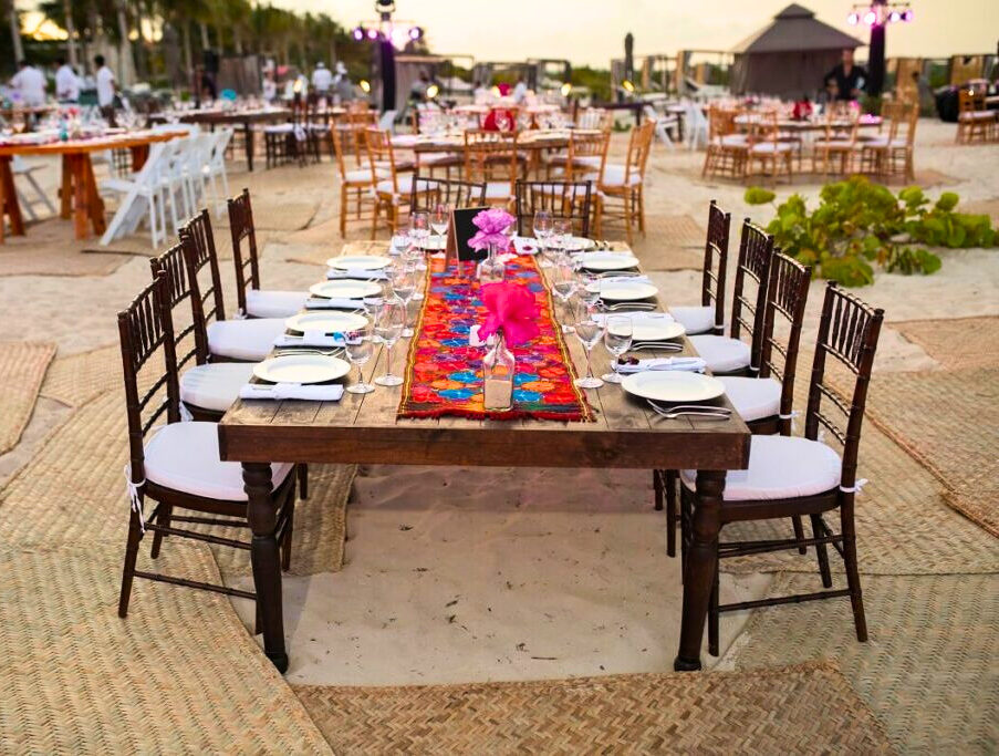Beach wedding reception with colorful runner on wooden table at atelier hotel