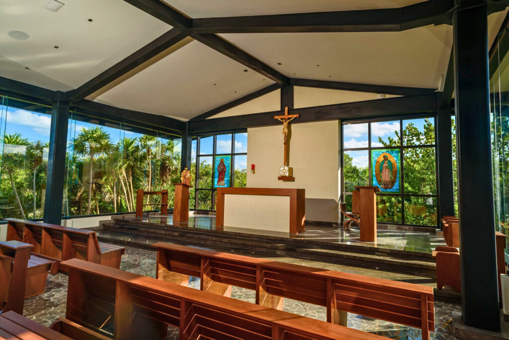 Inside of a resort chapel with glass walls and garden view