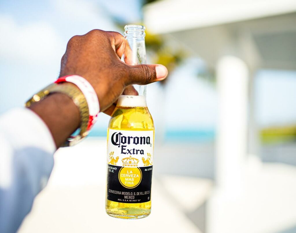 hand holding corona beer