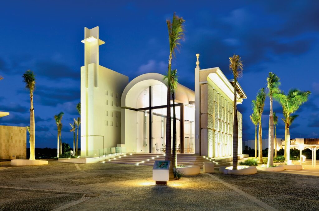 Luminous chapel surrounded by palm trees