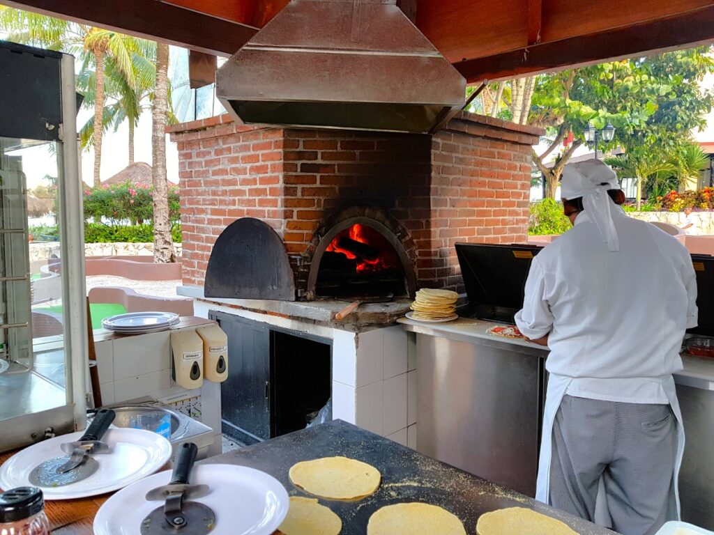 Grill with a brick over for with a cooker making pizzas