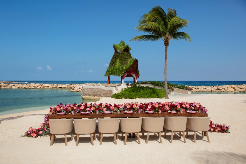 Beach wedding reception with a large table and a big flower centerpiece