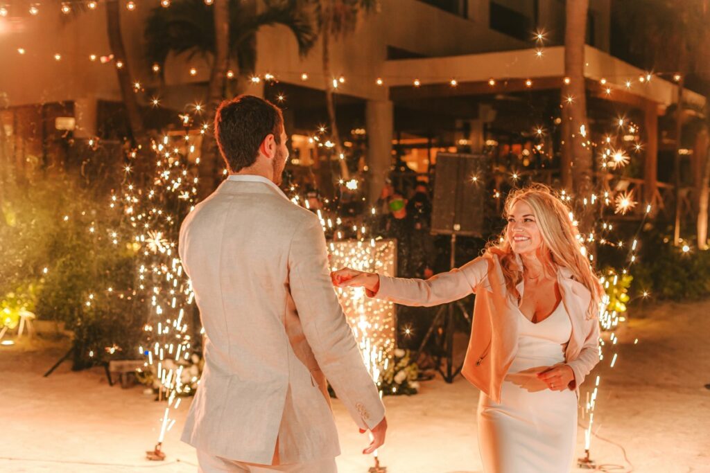 Just married couple on their first dance with firewors at the back
