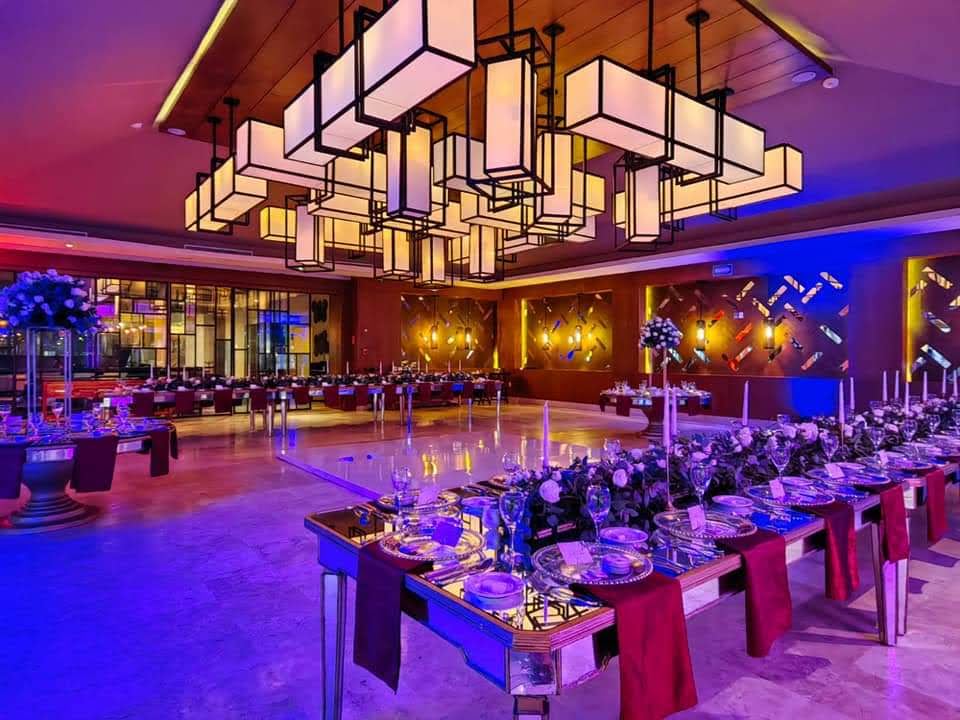 Wedding set up on a beautiful ballroom with hanging lanterns and purple and pink lights