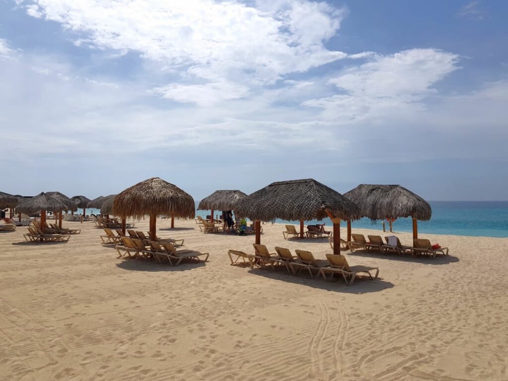Expansive beach area with palapa roof and lounge chairs