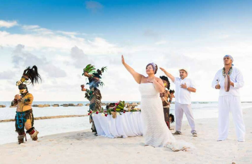 mayan beach wedding ceremony with prehispanic characters and a chaman