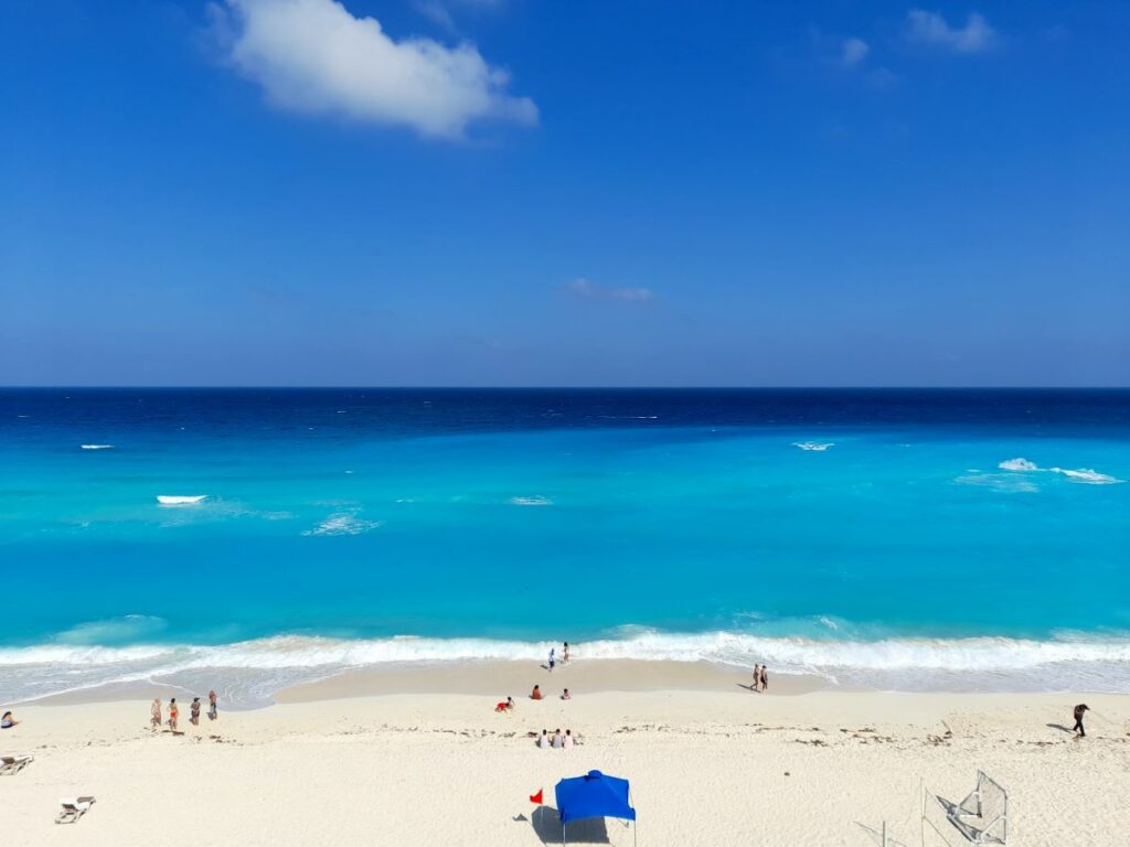 expansive blue beach with a few bathers in fiesta americana condesa cancun wedding resort