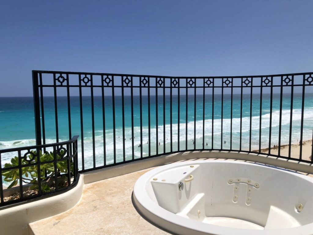 hotel room terrace with an outdoor jacuzzi and ocean view
