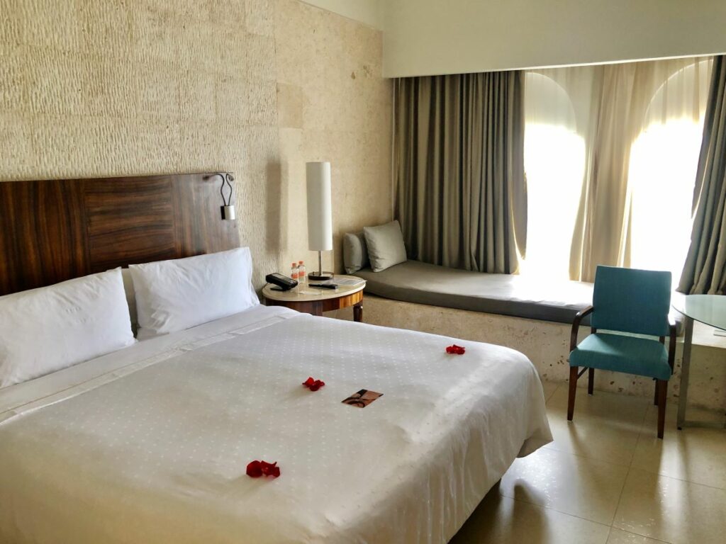 hotel room with one king size bed, warm tones and a large window