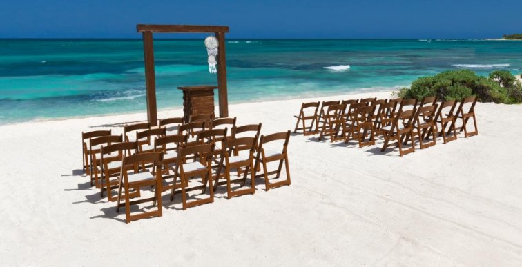 Unico Weddings on the beach - free ceremony set up with brown avant garde chairs and arch.