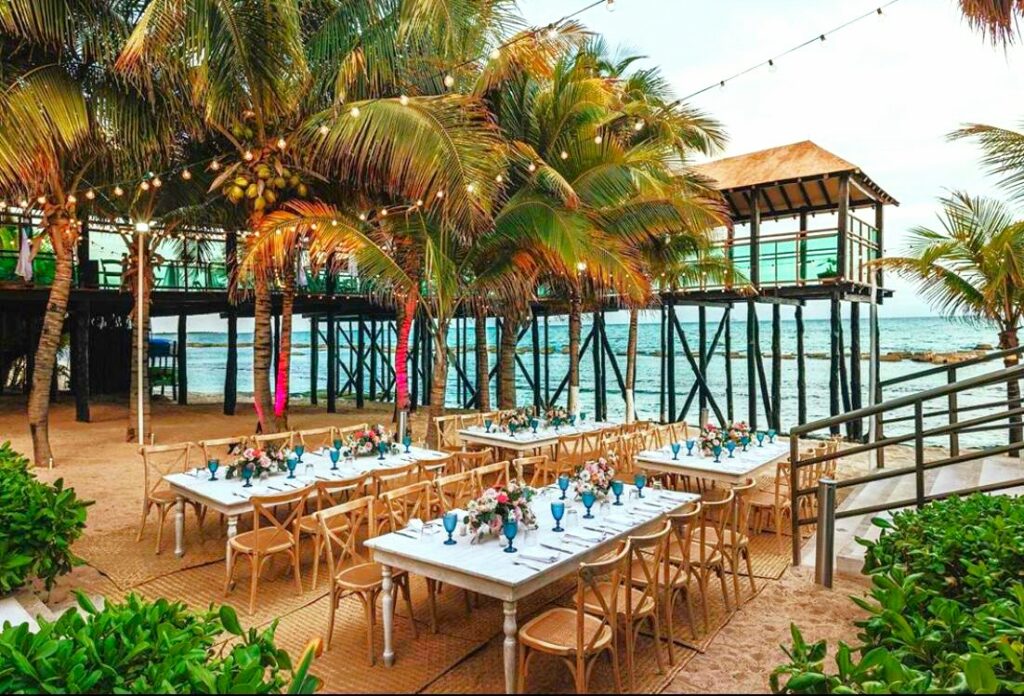 wedding set at the beach next to the pier boho decor and string lights