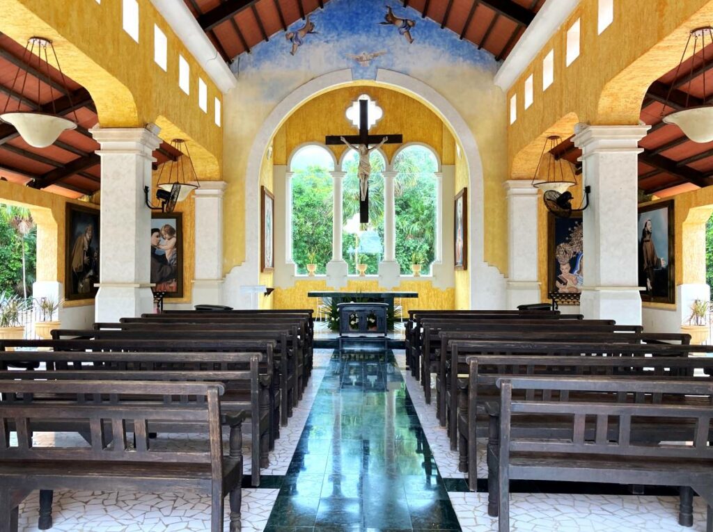 open catholic church with a cross at the end and large open windows