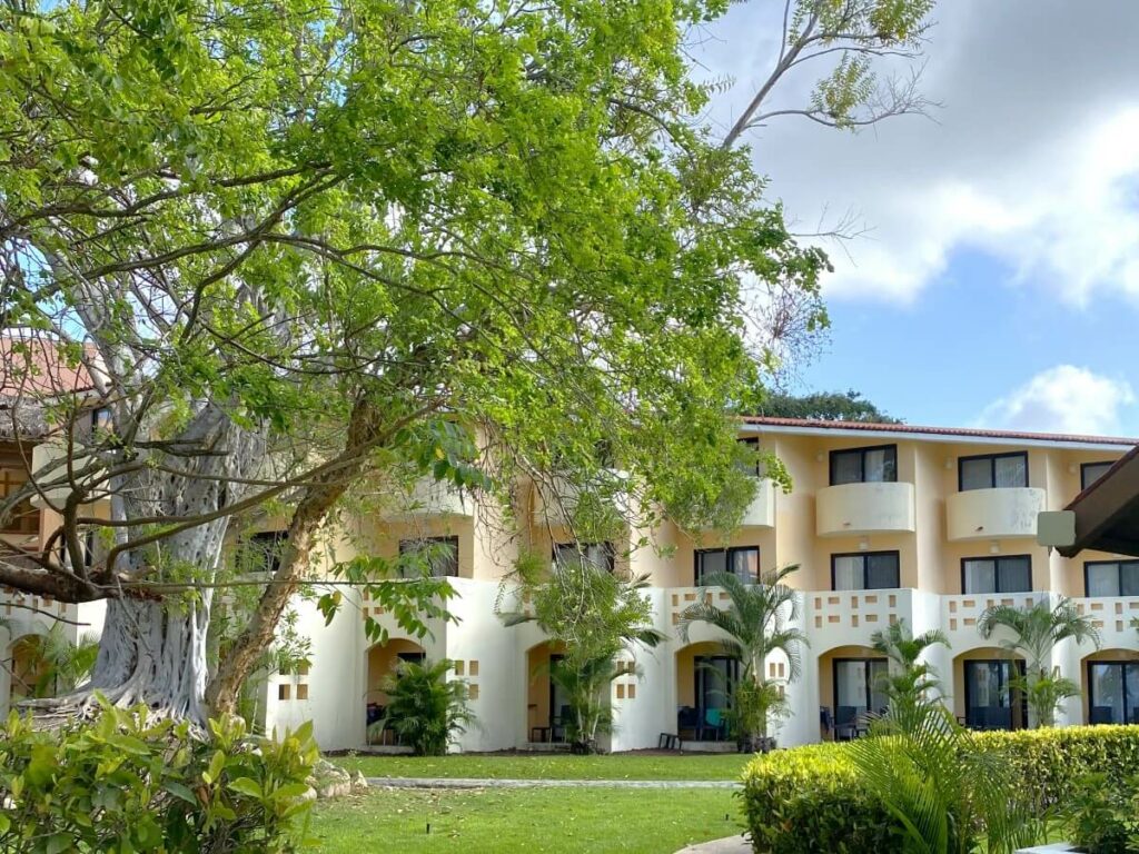 hotel room building with balconies and a large tree