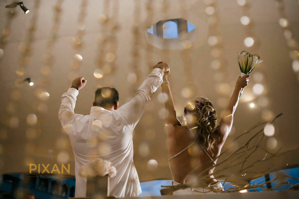 artistic wedding photo of bride and groom cheering