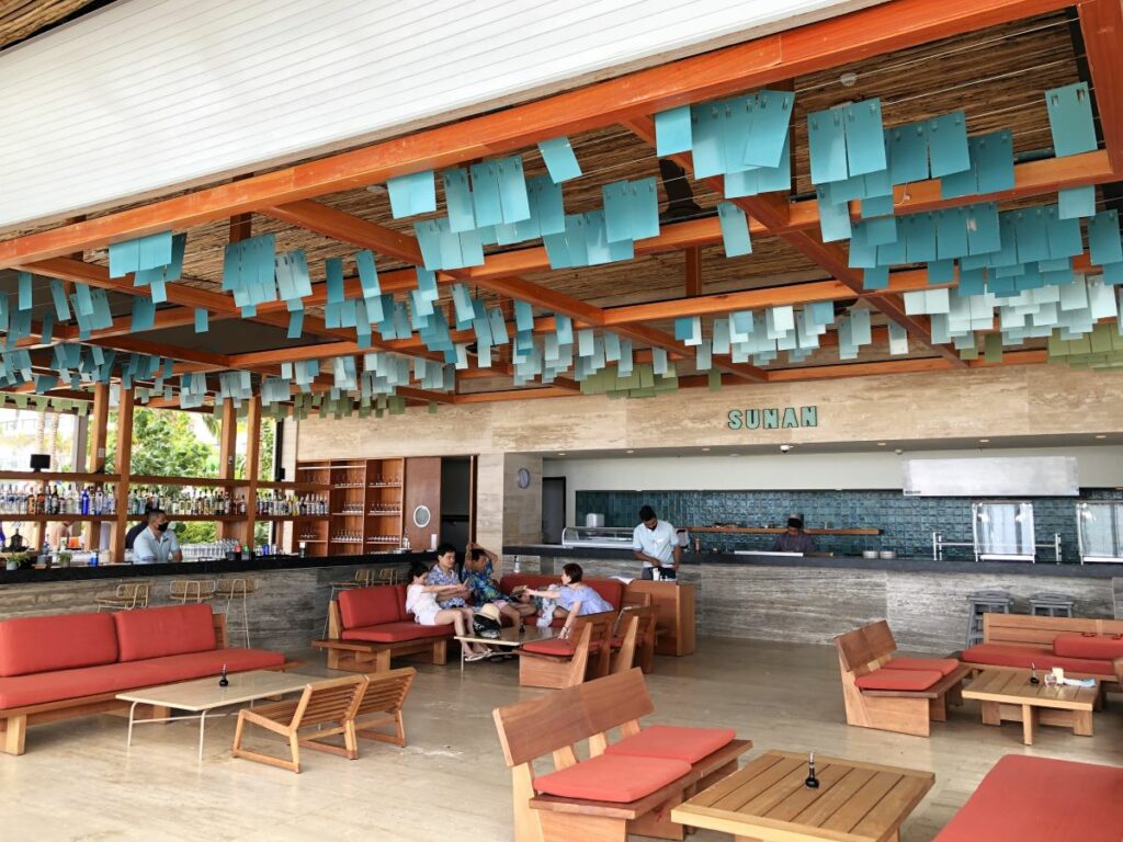 Open asian style restaurant with a sushi bar and lots of bottles