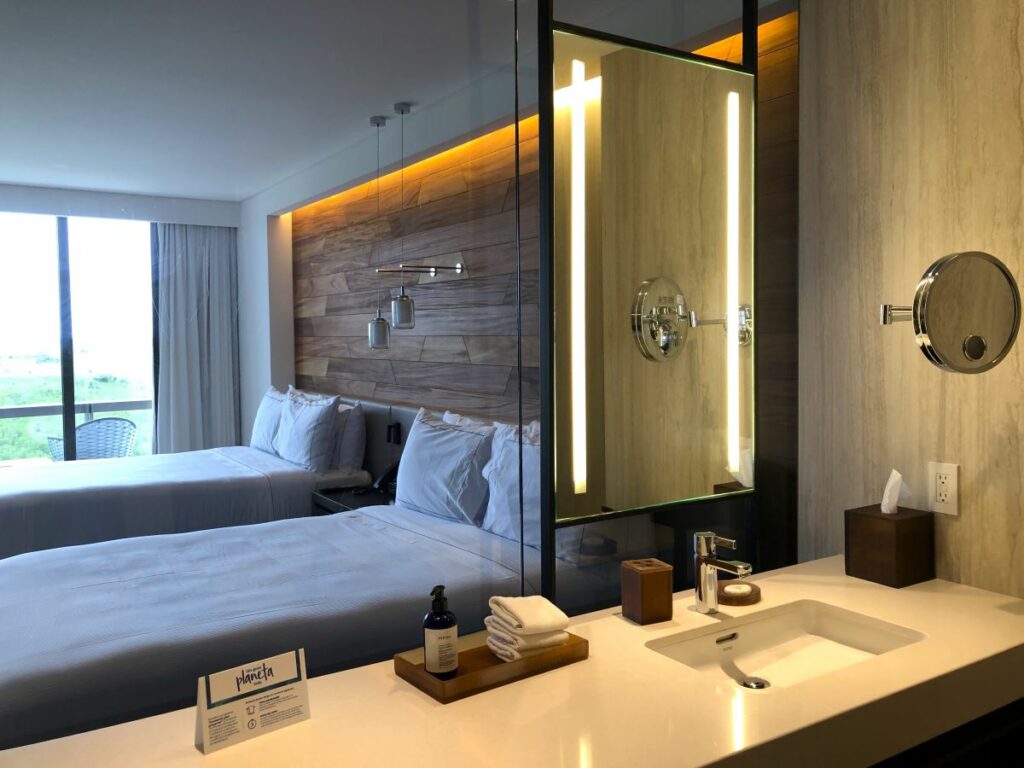 Hotel bathroom with a large mirror and view to the room