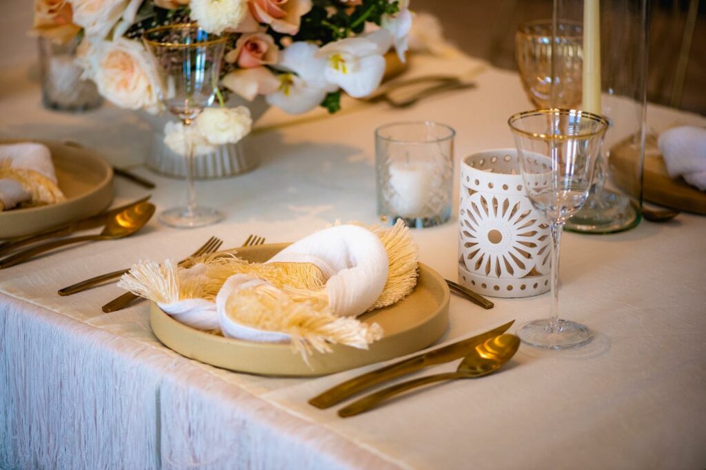 Wedding table set up with neutral colors, flowers and golden elements