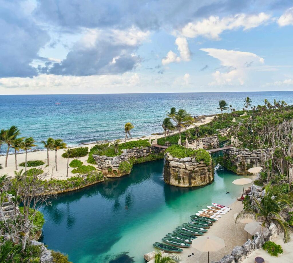 Aerial view of the ocean a river with some kayaks and paddle boards in the shore
