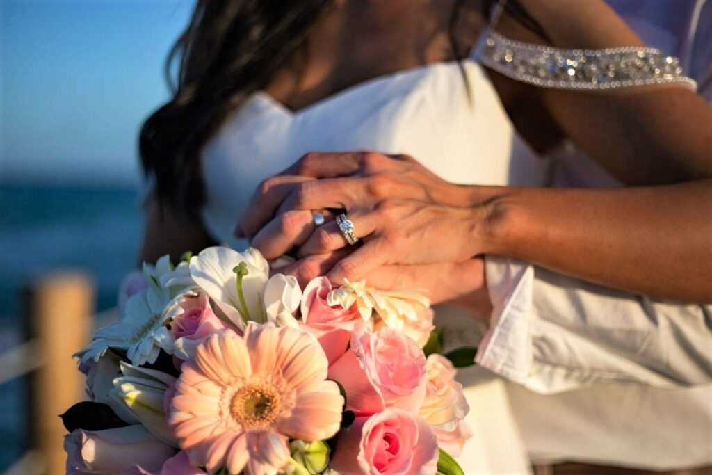 Just married couple holding each other with a flower bouquet