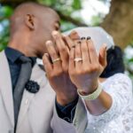 Just married couple showing their rings and kissing