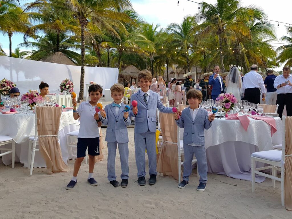 Kids at a beach wedding party holding maracas