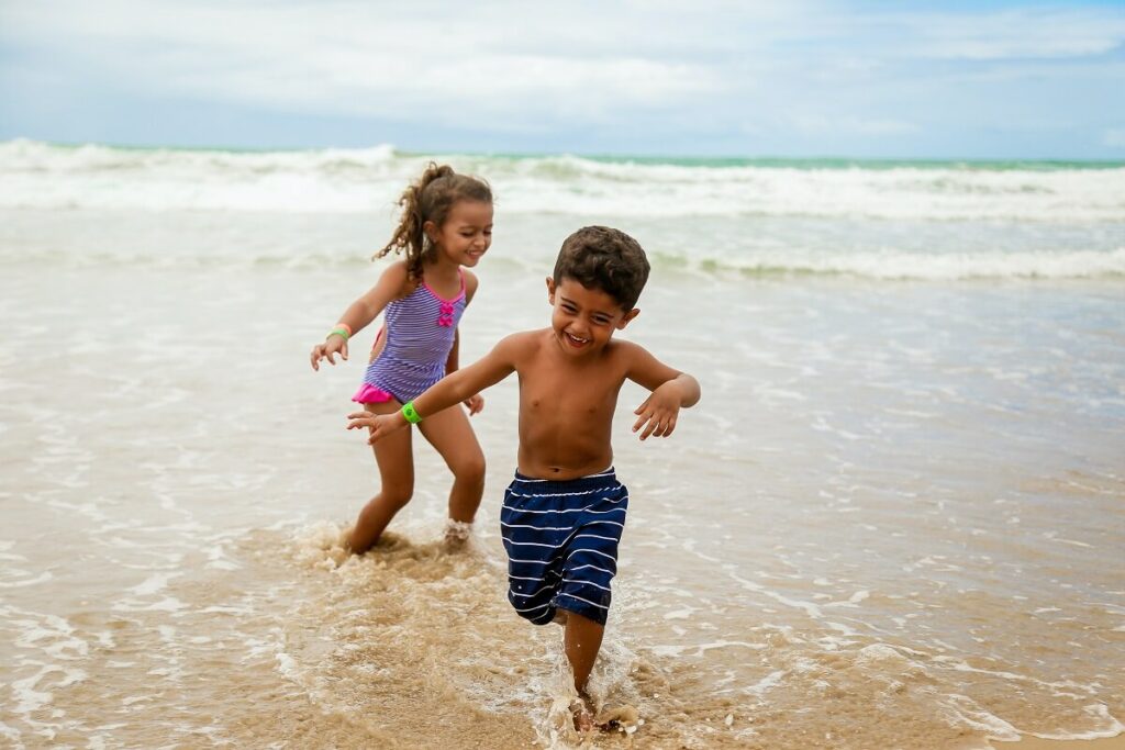boy and girl playing in the ocean