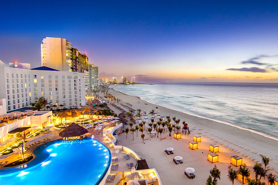 pool and beach at dusk in the cancun hotel strip