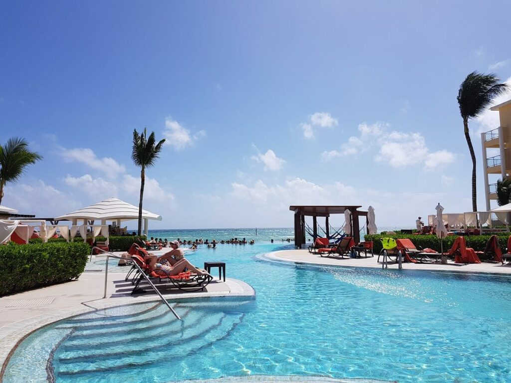 swimming pool with loungers and ocean view at now jade