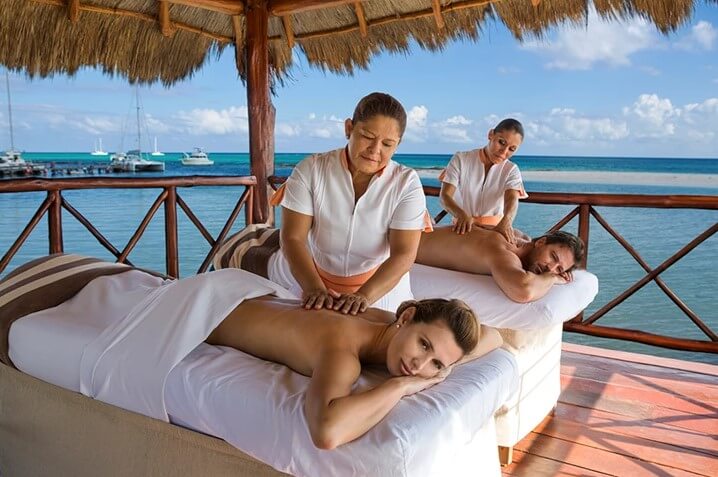 couples massage in outdoor hut over the ocean