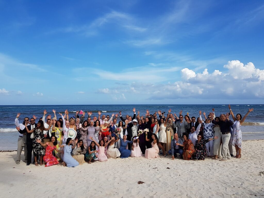 large wedding group on the beach at palladium colonial