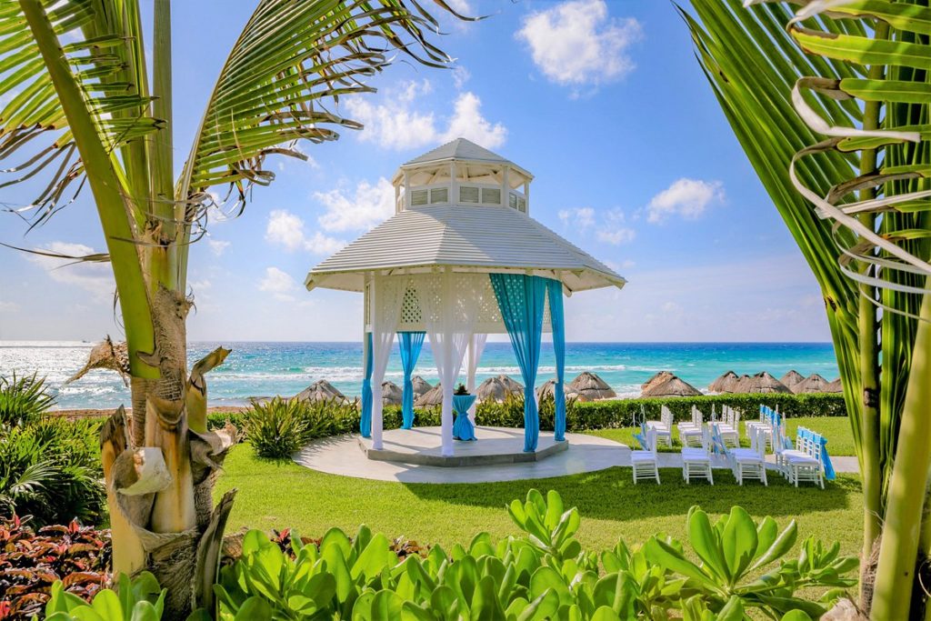 gazebo surrounded bye greens and white chairs
