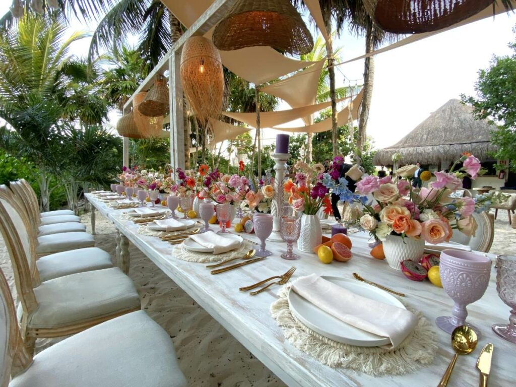 A beautiful wedding reception at the beach with pastel colors and hanging lanterns