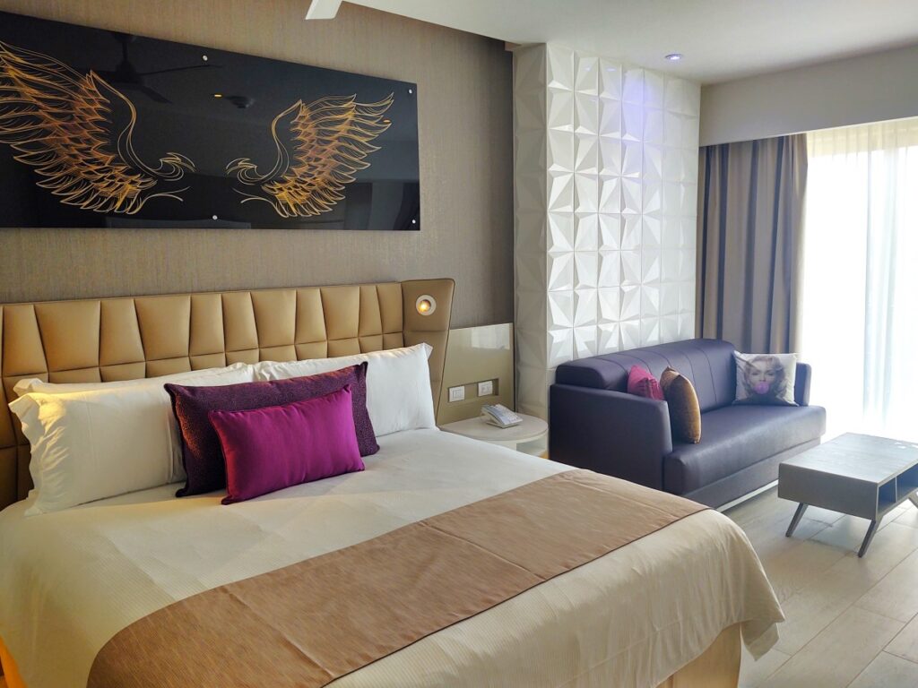 Hotel room with king size bed and a sofa bed and a large window