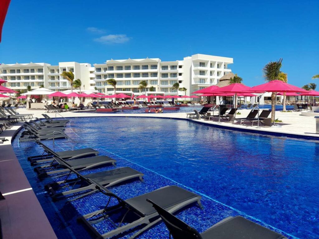 Expansive pool with loungers and purple umbrellas