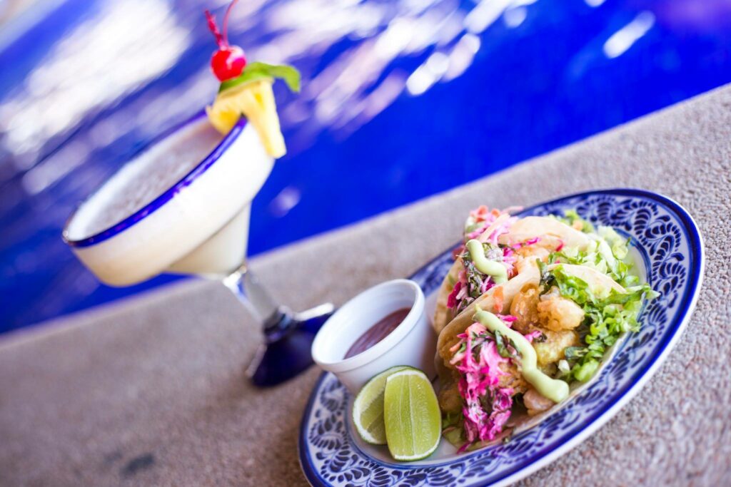 fish tacos with a pina colada by the pool