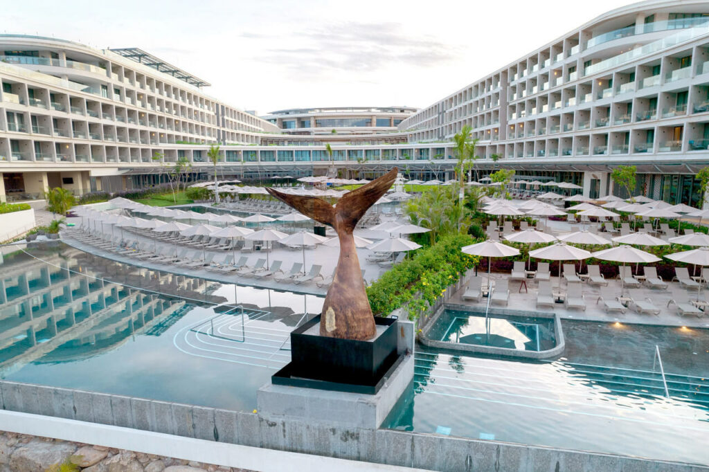Aerial view of hotel with pools and a whale tale sculpture