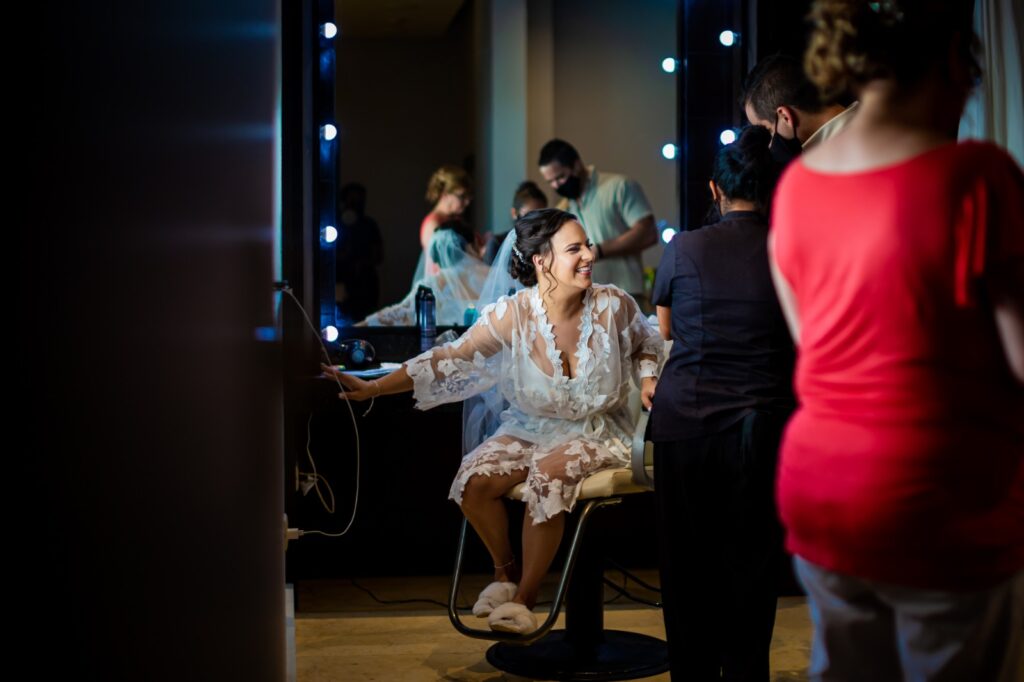 Bride getting ready at the spa salon dressed in a white silk robe with some girlfriends