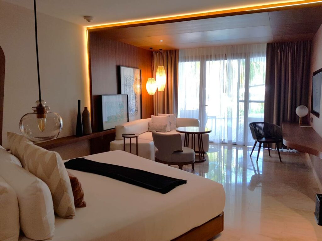 Junior suite room with one king size bed, wooden walls, seating area and hanging lanterns