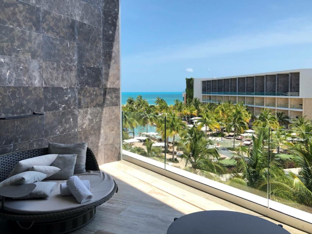 Ample terrace with a lounge couch and panoramic view of the resort and the beach