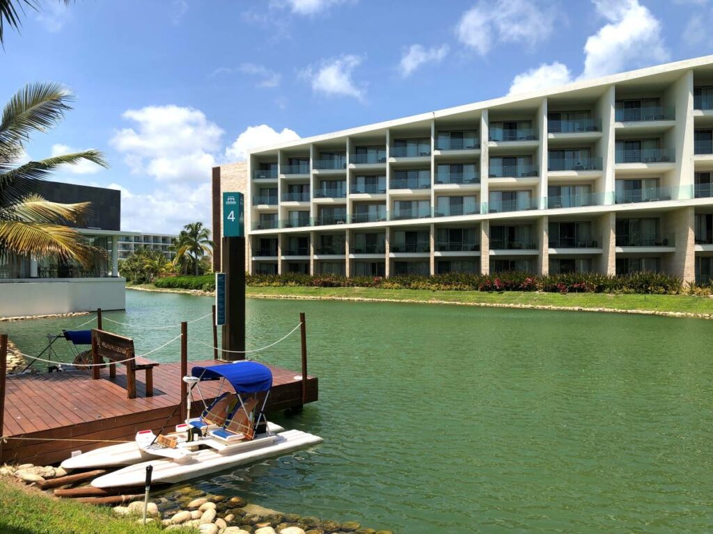 Water canal with a deck and a boat, and a room building at the back