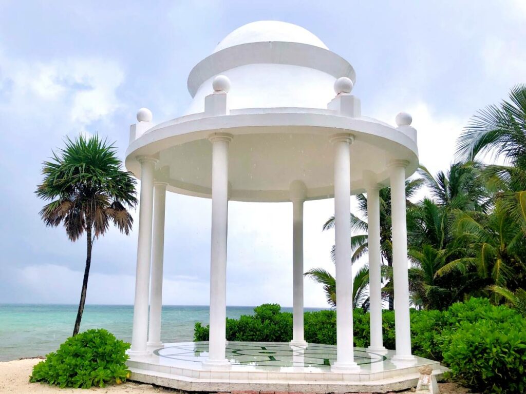 resort wedding ceremony at the beach shore with pink flowers in the chairs