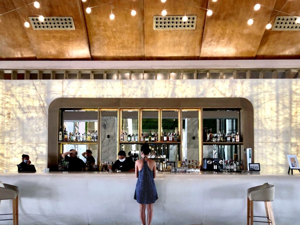 Resort lobby bar with big mirrors and a lady ordering a drink