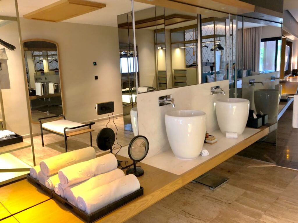 Hotel bathroom area with two double vanities and lots of mirrors