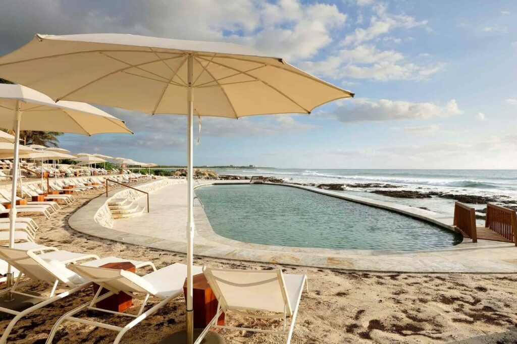Saltwater pool with lounge chairs and umbrellas