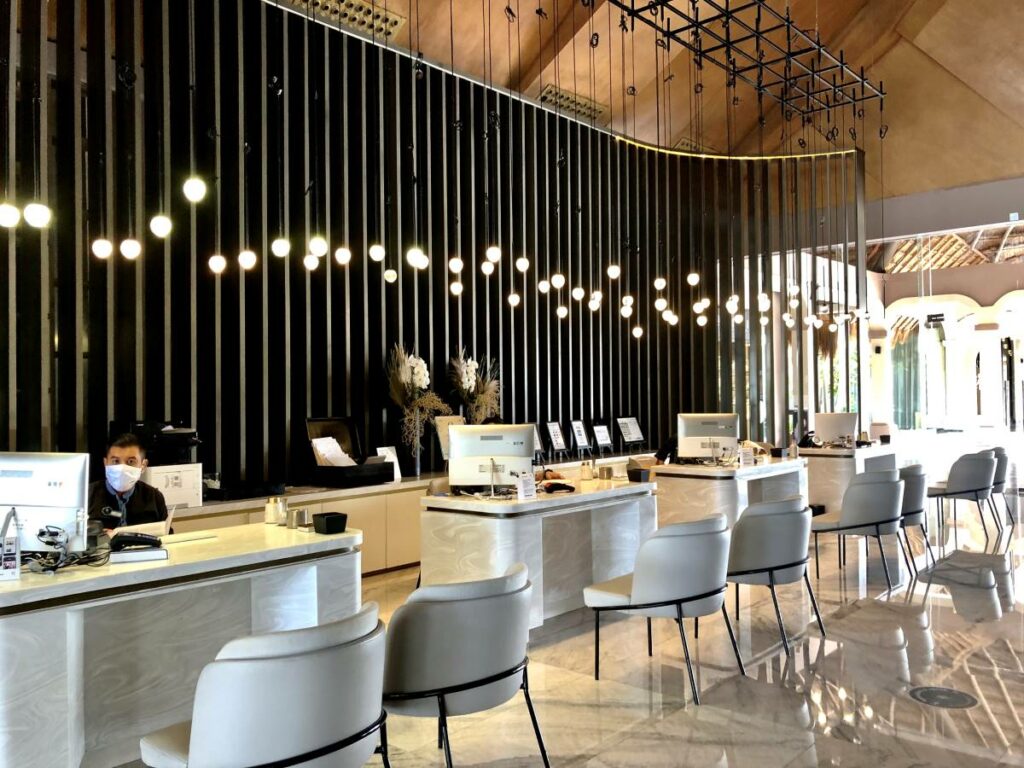 Modern resort front desk with hanging lightbulbs and marble furniture