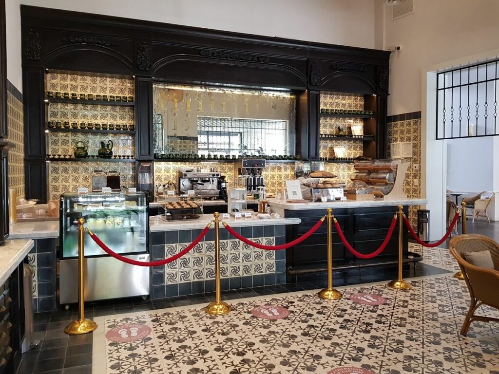 cafe area with artistic ceramic, dessert counter and coffee machines