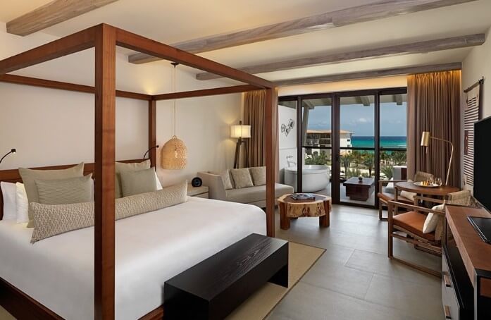 hotel room interior with king 4 poster bed and sitting area at unico hotel
